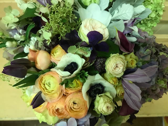 Bouquet of pale peach, white, and dark purple flowers
