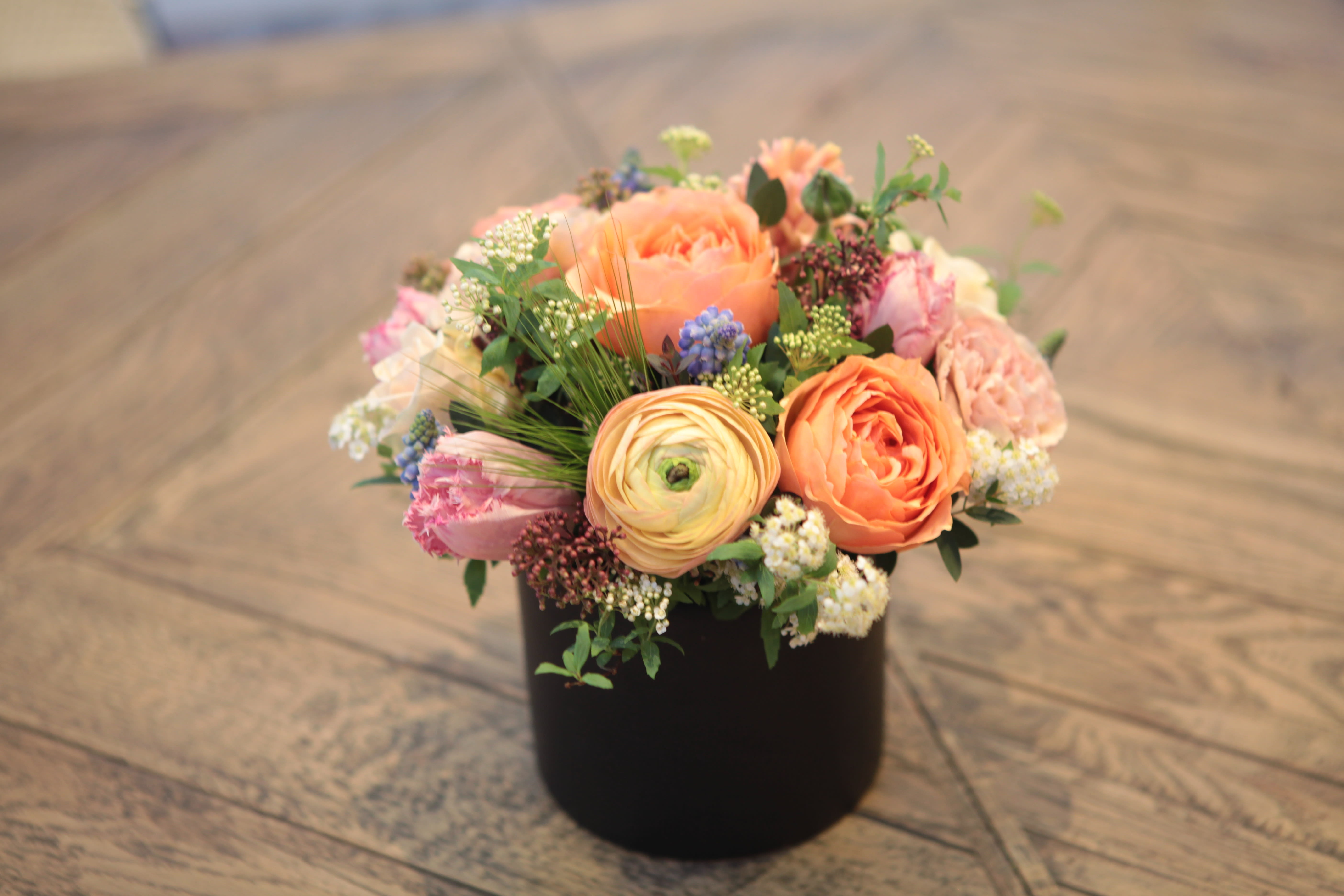 Peach and pink mixed bouquet in a black container