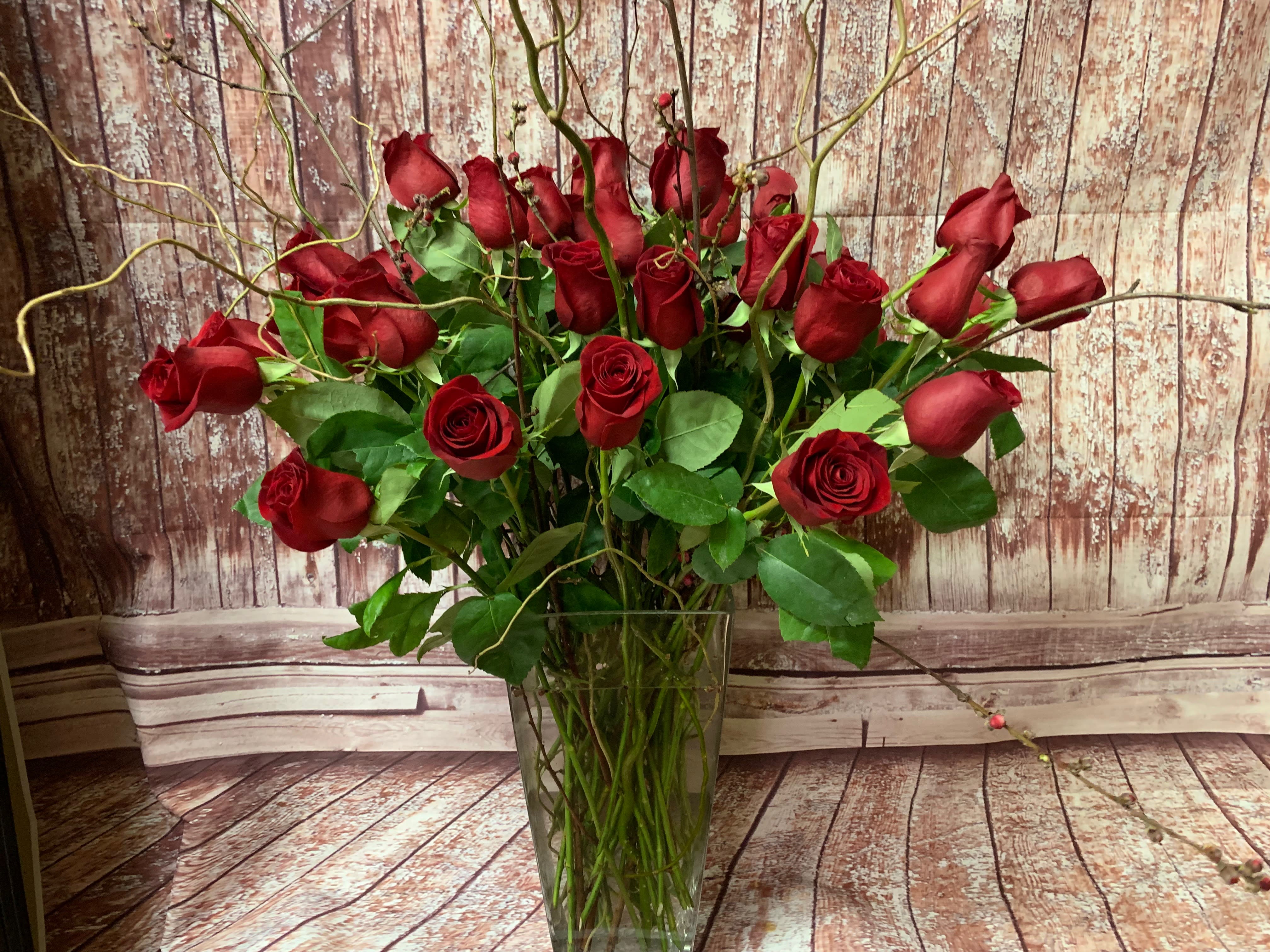 Red roses arranged in a clear glass vase