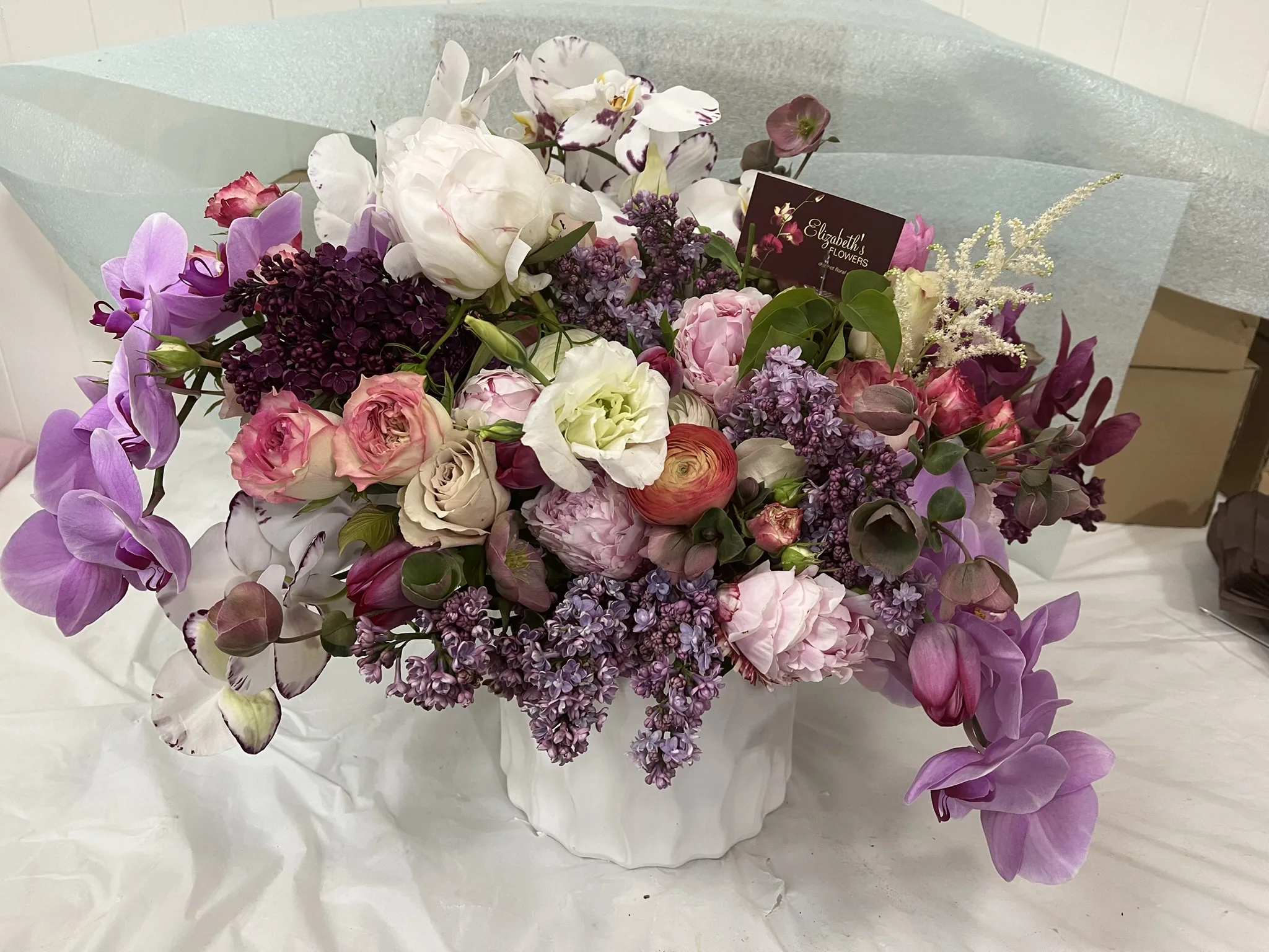 Mixed bouquet in a white vase with purple, pink, and white flowers