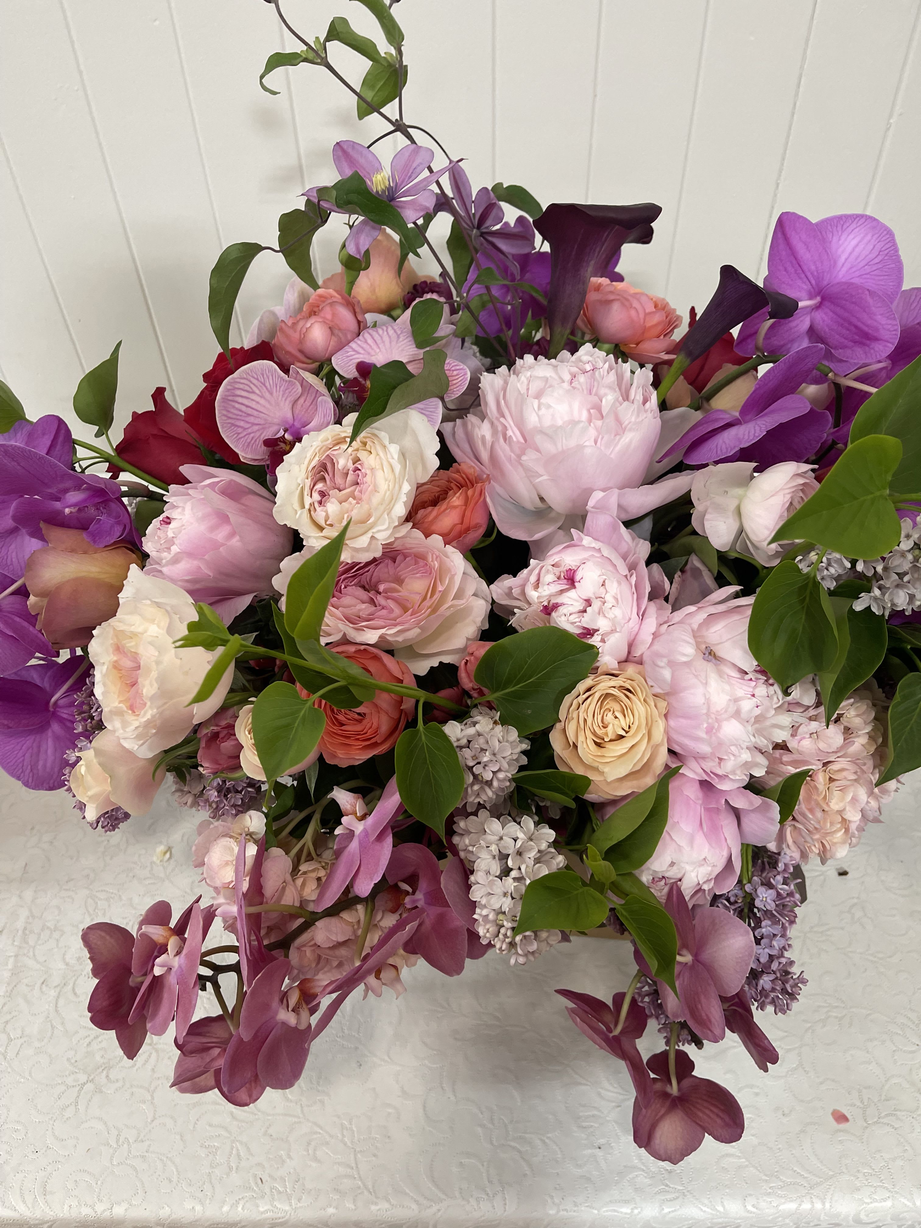 Mixed pink and purple bouquet with roses, orchids, and calla lilies