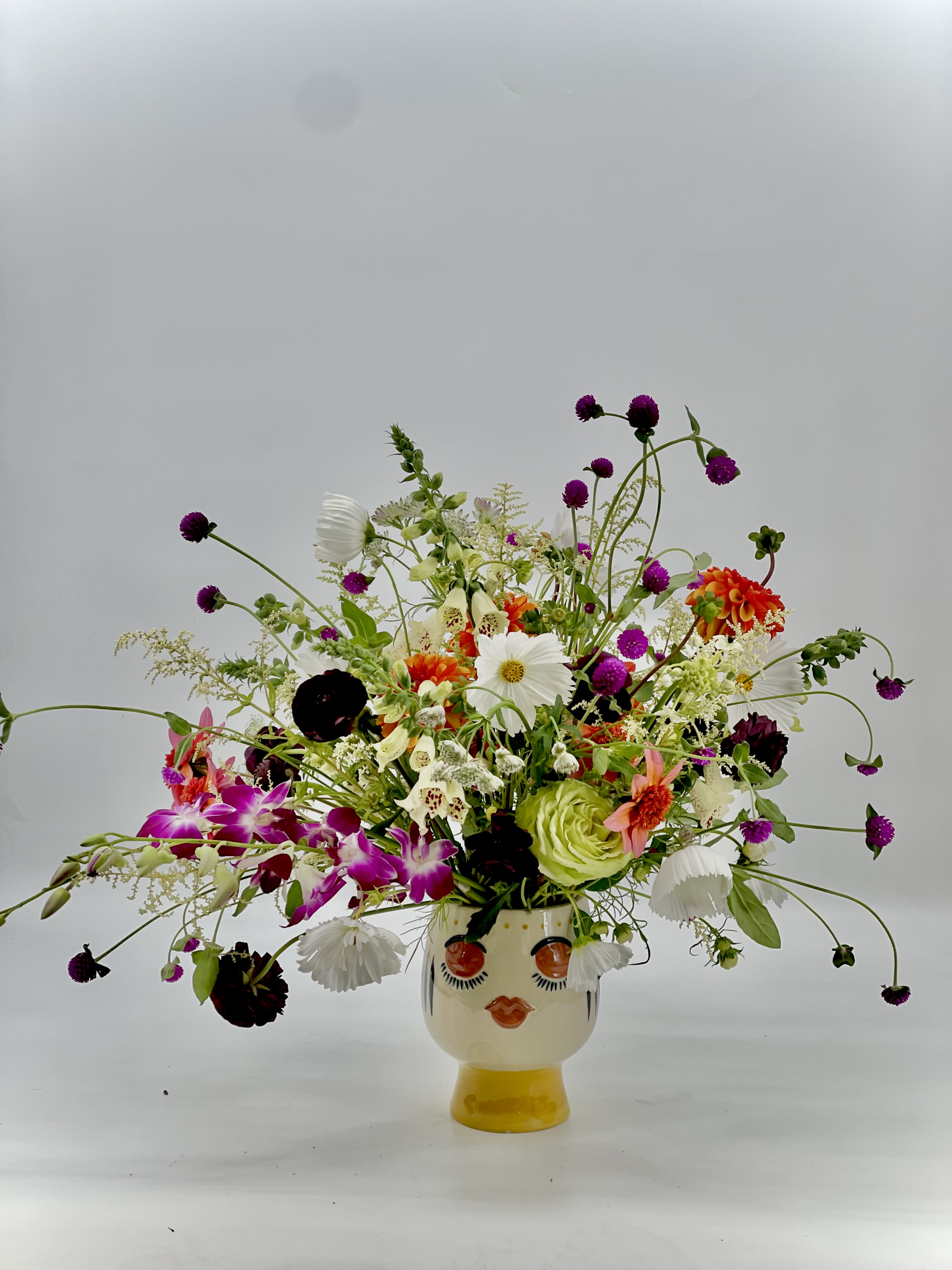 Colorful mixed bouquet in a face-shaped ceramic vase