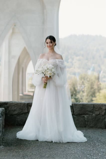 Bride in a white gown holding a white bouquet