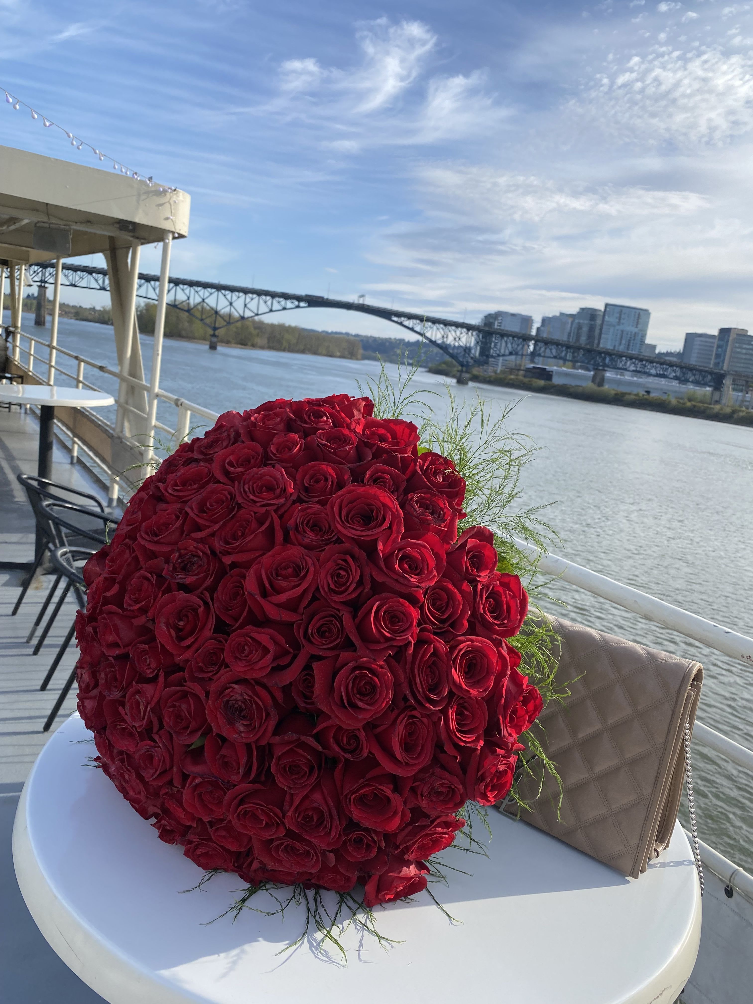 Large bouquet of red roses on a table by the water