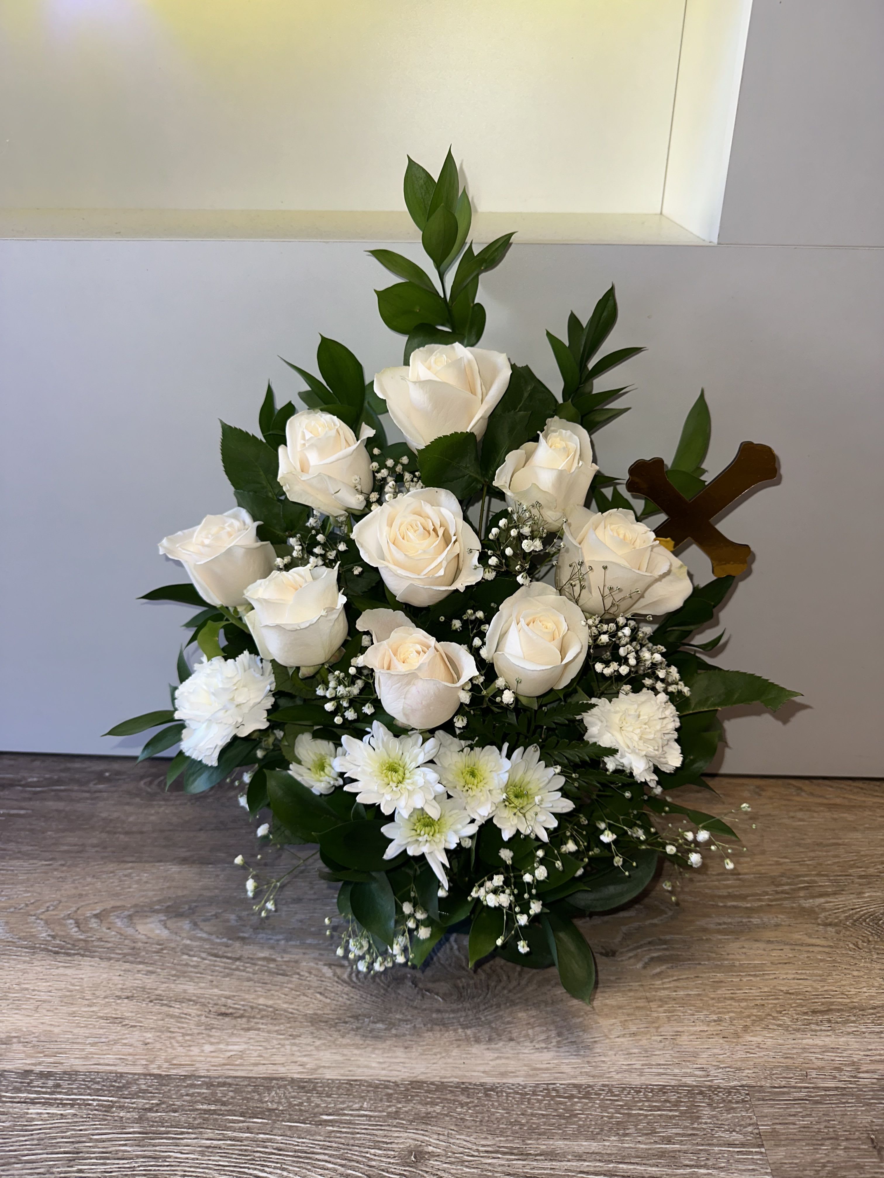 White roses and daisies arranged with baby's breath in a low bouquet