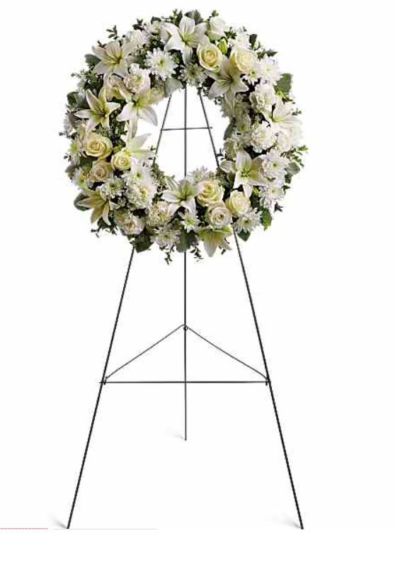 Serenity Wreath - Fragrant and ethereal white blossoms set among a ring of soothing greens form a classic wreath certain to evoke the pure heart and gentle spirit of a loved one - and offer consolation during a funeral or wake.  - Delivered on an easel, a standing wreath comprising fresh flowers such as white roses, Asiatic lilies, carnations and chrysanthemums, as well as greens including salal.  Orientation: One-Sided  SUBSTITUTION POLICY Please note the bouquet pictured reflects our original design.  If the exact flowers or container in this arrangement are not available, our local florists will create a beautiful bouquet with the freshest available flowers.