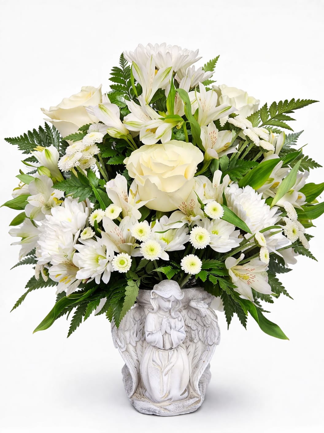 Heavenly Grace Angel  - A serene dome of soft white and cream roses, daisy-style chrysanthemums, and alstroemeria creates the calm, uplifting focal point of this sympathy flower arrangement. The white ceramic angel vase-sculpted in a praying pose-gives the design a comforting, spiritual presence, making this arrangement a meaningful choice for sympathy, memorials, or to offer quiet support to someone grieving.  Flowers are clustered densely for a full, rounded silhouette with subtle green foliage peeking through and bright yellow chrysanthemum centers that lend gentle warmth to the neutral palette. The mix of roses, chrysanthemums, and alstroemeria offers varied textures-from velvety rose petals to the crisp, cheery faces of the mums-so the bouquet reads both lush and tender in any room.  Perfect for sending condolences, marking a memorial service, or leaving at a graveside, this arrangement speaks of thoughtfulness and reverence that the recipient will notice. The ceramic angel vase is keepsake-worthy and can be reused; please follow standard fresh-flower care-trim stems, change water regularly, and keep away from direct heat-to extend the life of the blooms.