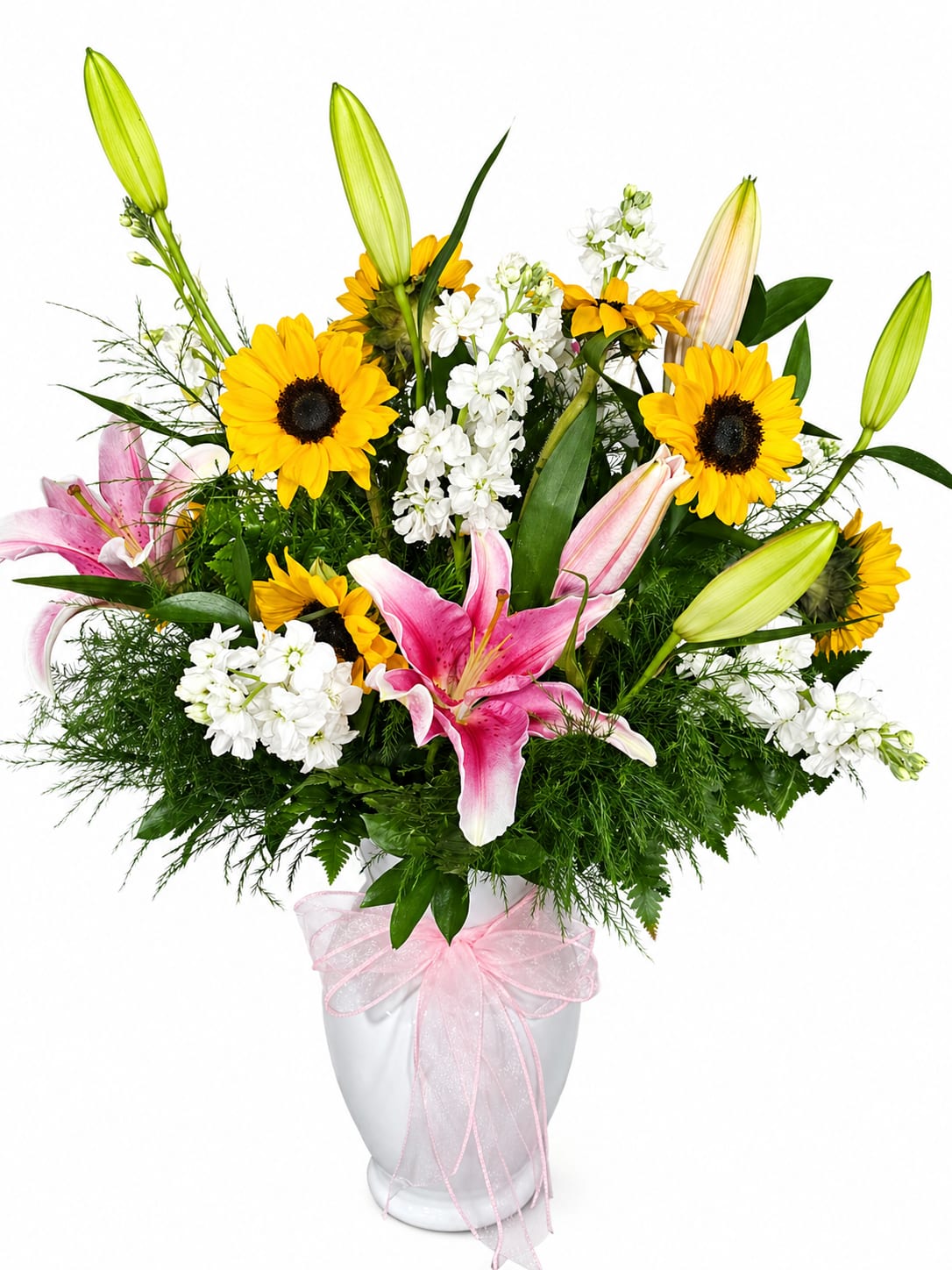 Blush &amp; Sunshine for Mom - Celebrate her with a bouquet as beautiful and loving as she is. Blush &amp; Sunshine for Mom is a stunning arrangement that combines vibrant sunflowers with elegant pink lilies and soft white blooms—creating the perfect balance of warmth, grace, and beauty.  The cheerful sunflowers symbolize happiness and admiration, while the delicate pink lilies express love and appreciation—making this arrangement a heartfelt way to honor everything Mom means to you. Designed with lush greenery and seasonal accents, and presented in a classic white keepsake vase finished with a soft pink ribbon, this bouquet is both timeless and unforgettable.  Whether you’re near or far, this radiant design is the perfect way to say “Thank you, Mom, for everything.”  Details:  Fresh sunflowers, pink lilies, and seasonal white blooms Lush greenery and premium filler accents Designed in a white ceramic keepsake vase Finished with a soft pink decorative ribbon