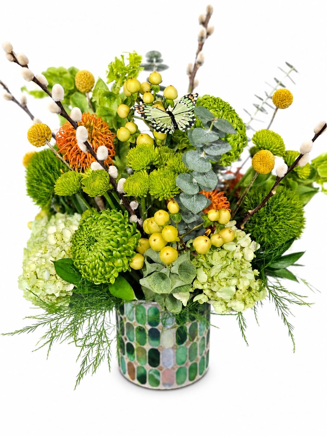 Butterfly Kisses for Mom - Celebrate Mom with a design as vibrant and graceful as she is. Butterfly Kisses for Mom features a lush blend of fresh green blooms, cheerful yellow accents, and unique textured florals, artfully arranged in a modern mosaic vase. Delicate pussy willow branches and a charming butterfly detail add a whimsical, springtime touch.  This eye-catching arrangement brings together elegance and playfulness—perfect for brightening her day and showing just how much she means to you.  A beautiful way to say thank you, I love you, and you deserve the world this Mother’s Day.