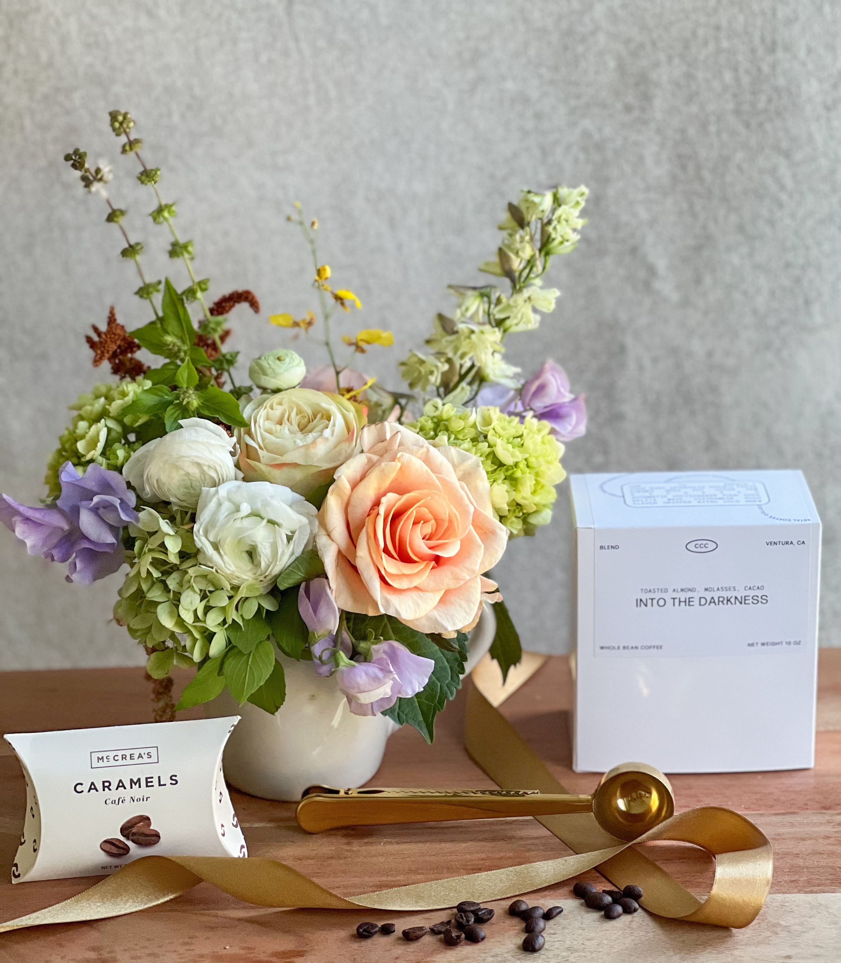 Mixed bouquet in a white vase with coffee and caramel gift items