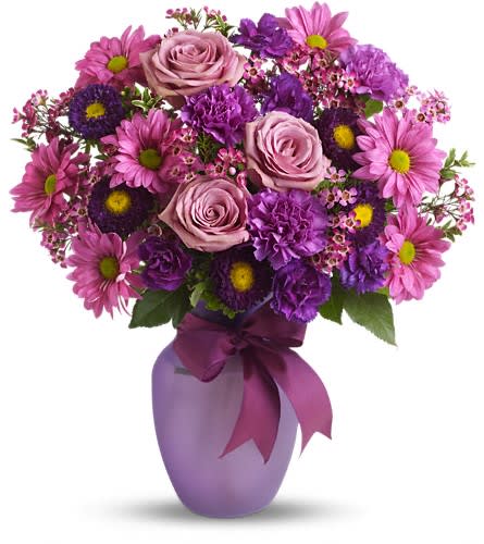 Pink and purple bouquet in a lavender vase with a ribbon