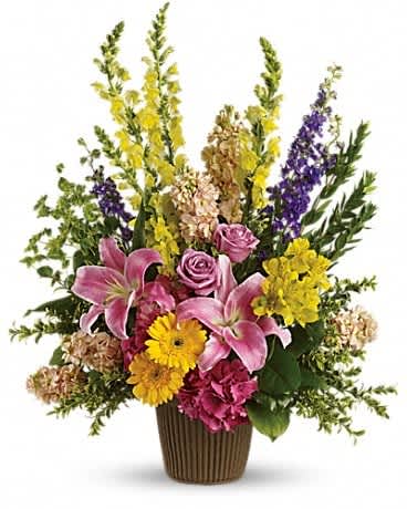 Mixed bouquet with pink lilies, roses, and yellow flowers in a brown vase