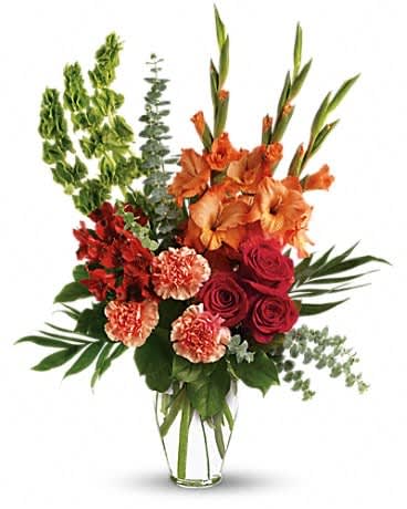 Tall bouquet of orange gladiolus, red roses, and carnations in a clear vase