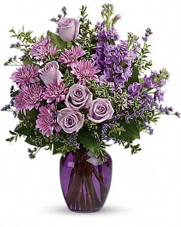 Lavender roses and purple flowers in a purple glass vase