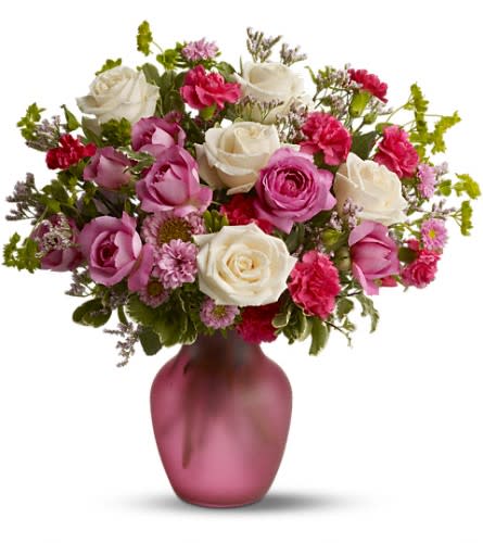 Pink and white rose bouquet in a frosted pink vase
