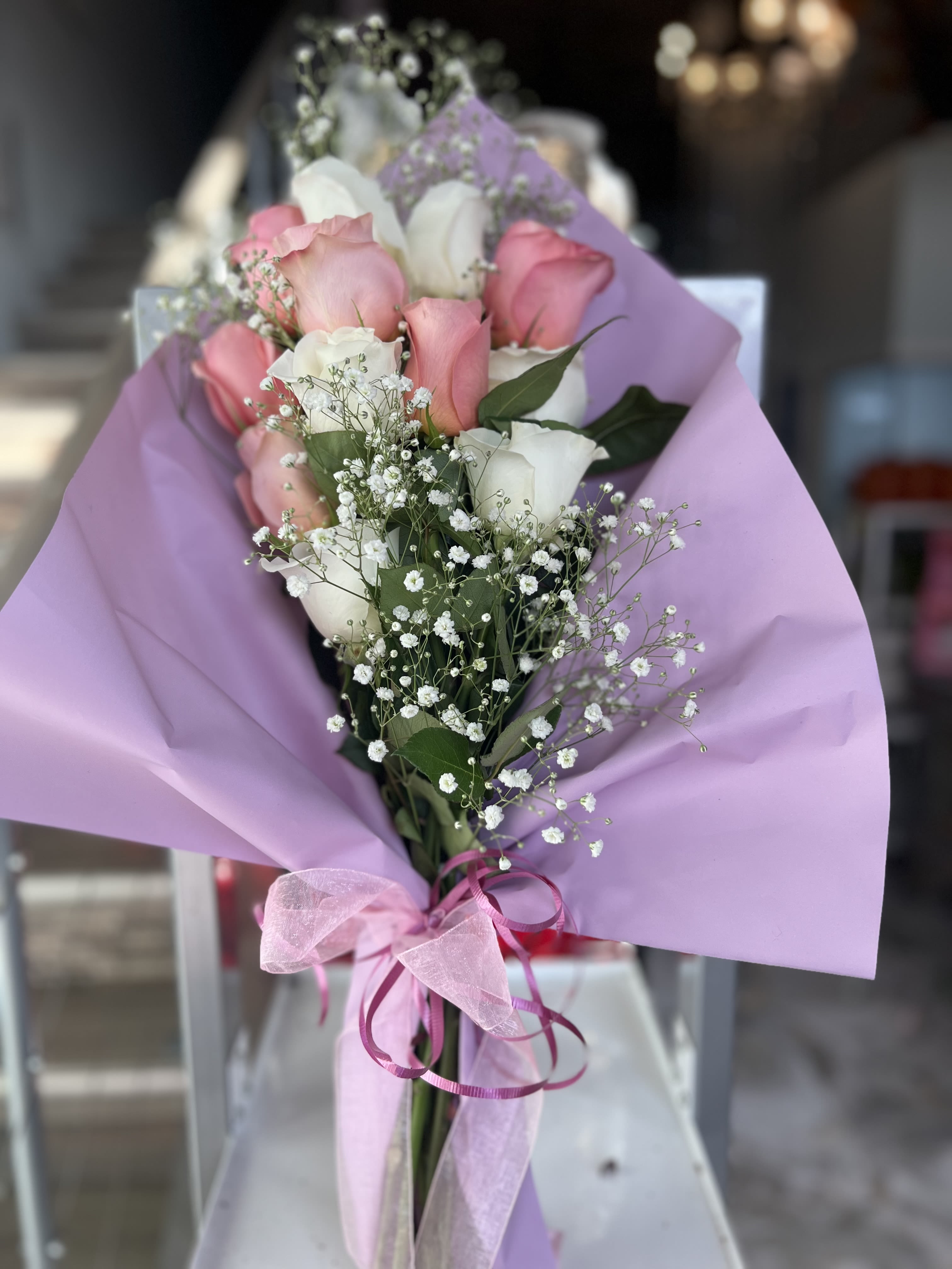 Bouquet of pink and white roses wrapped in lavender paper