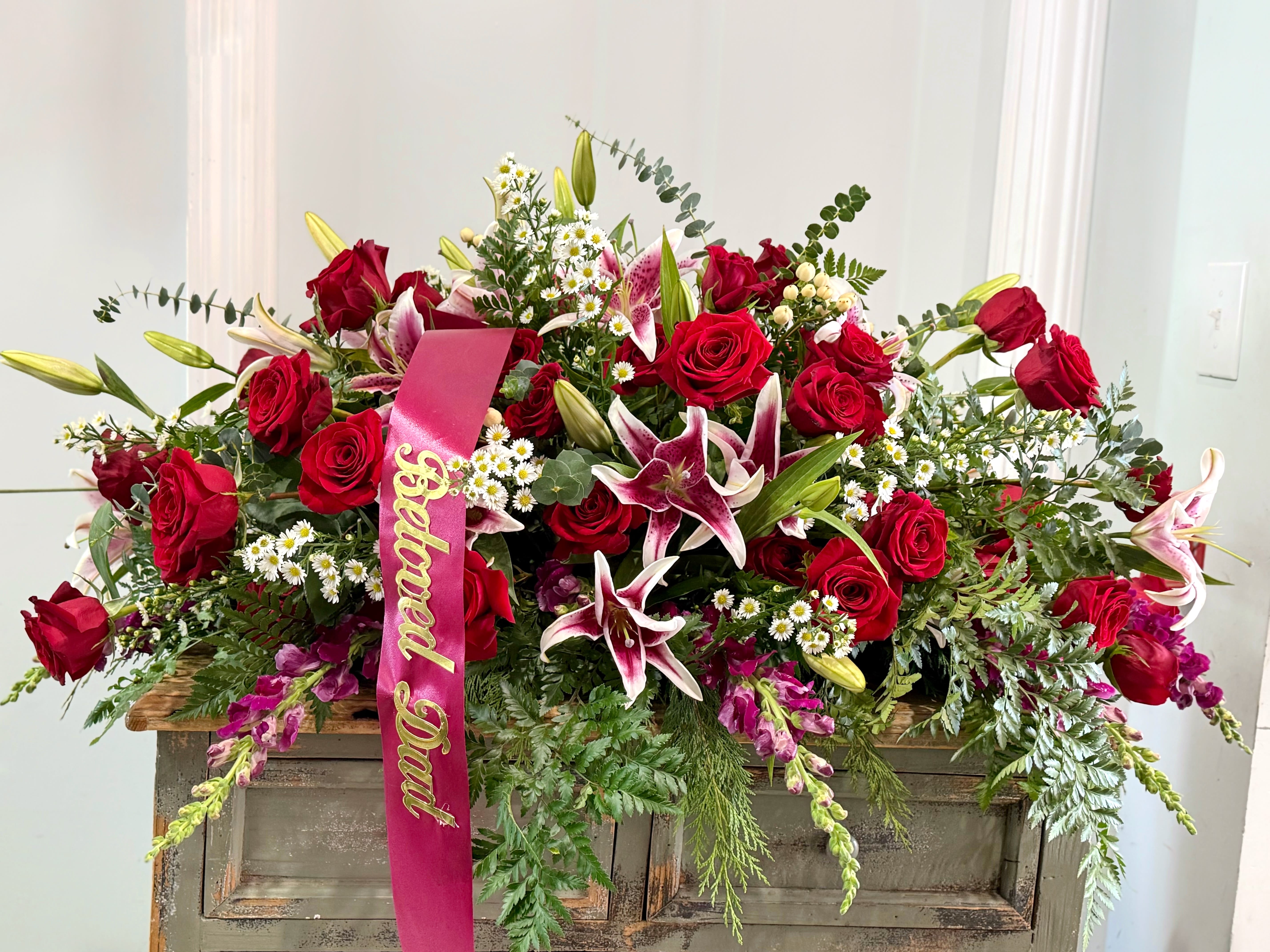 Large red rose and lily arrangement with a pink "Beloved Dad" ribbon