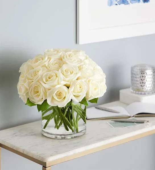 White rose bouquet in a clear glass vase on a table