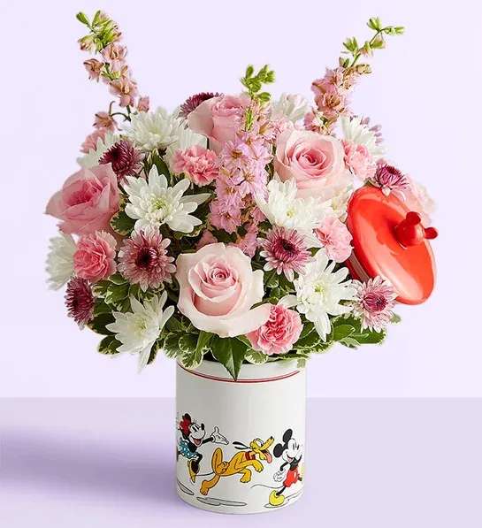 Pink and white flower arrangement in a Mickey Mouse tin with a red heart topper