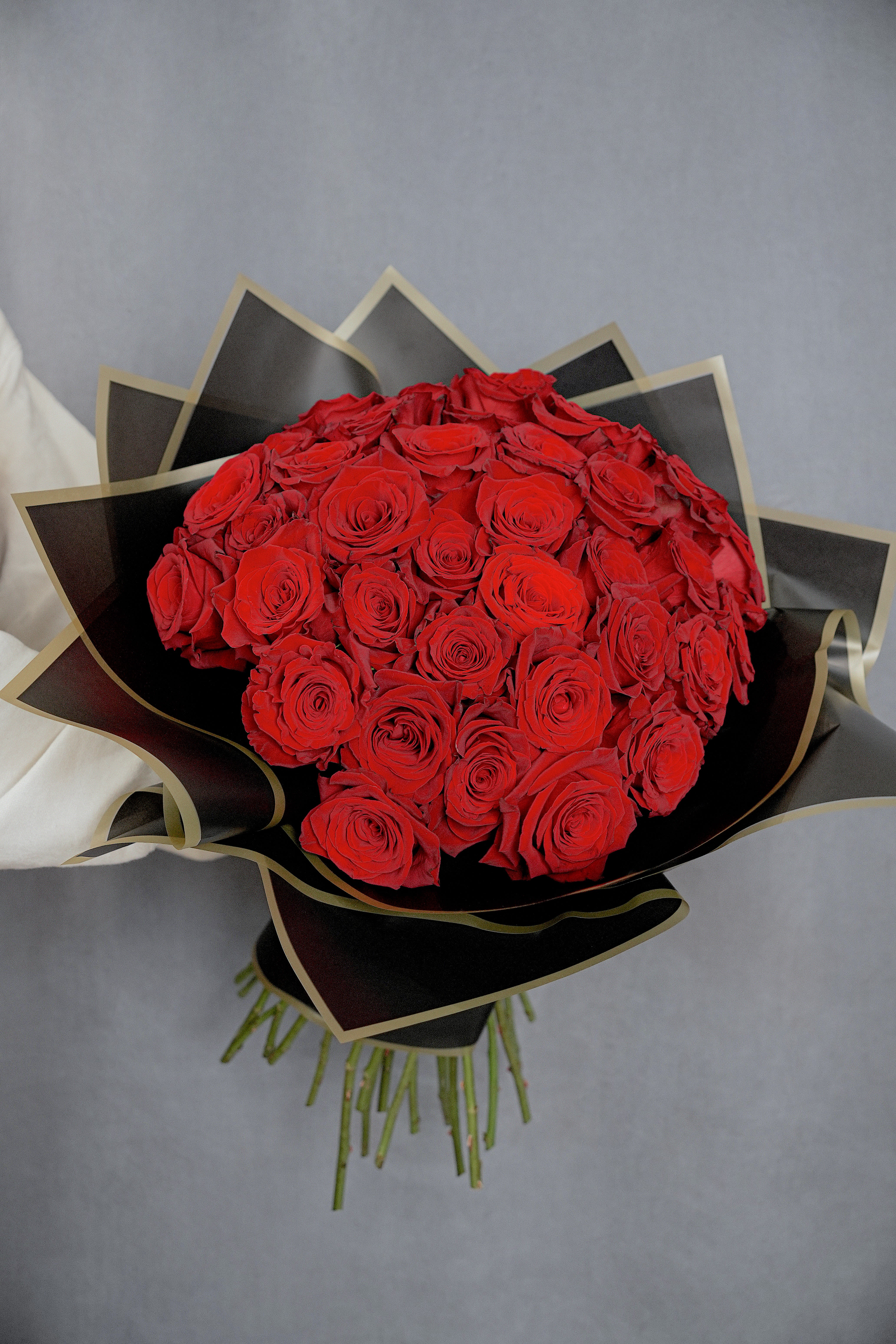 Bouquet of red roses wrapped in black paper