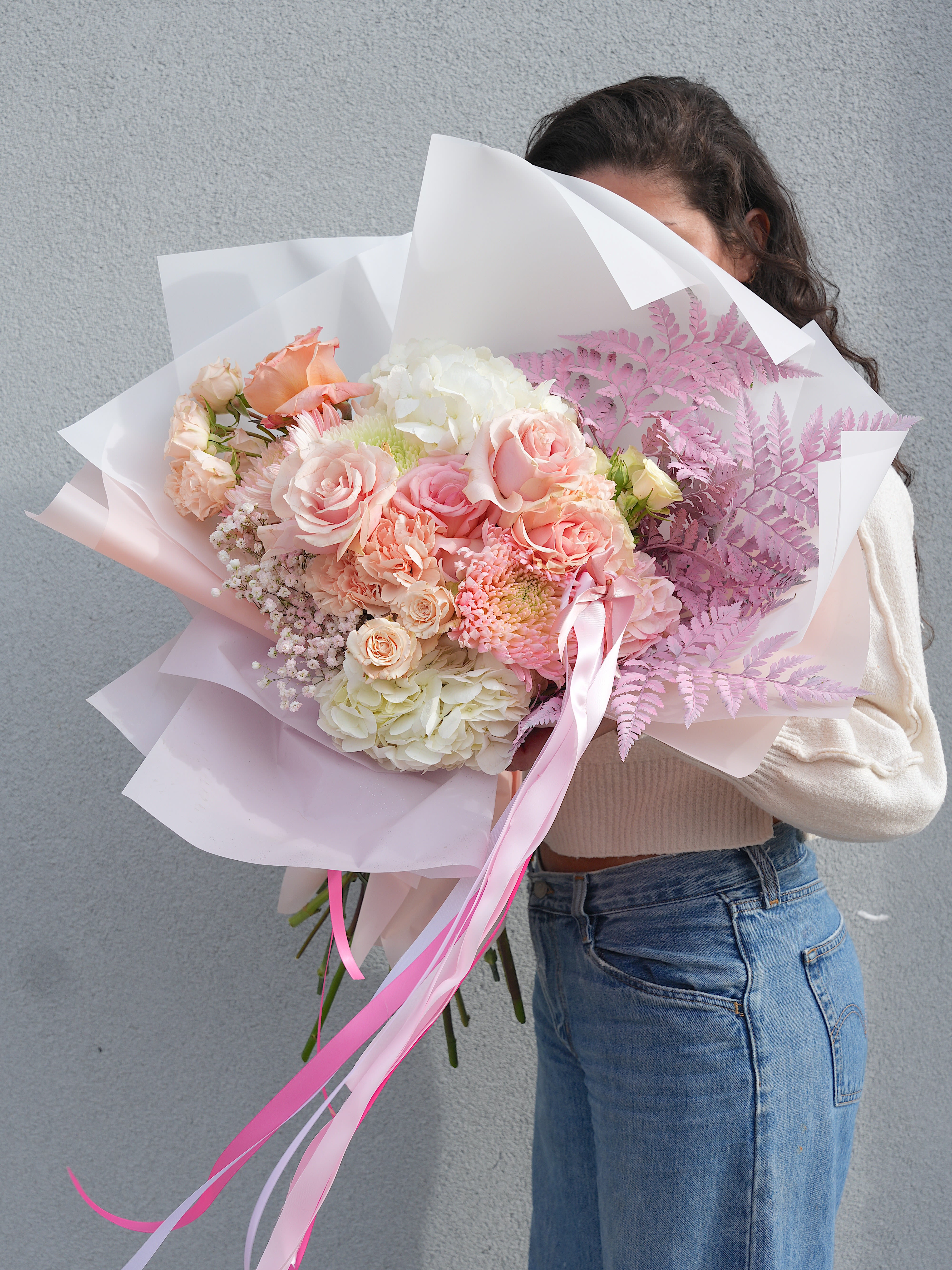 Large pastel bouquet of pink and white flowers wrapped in paper