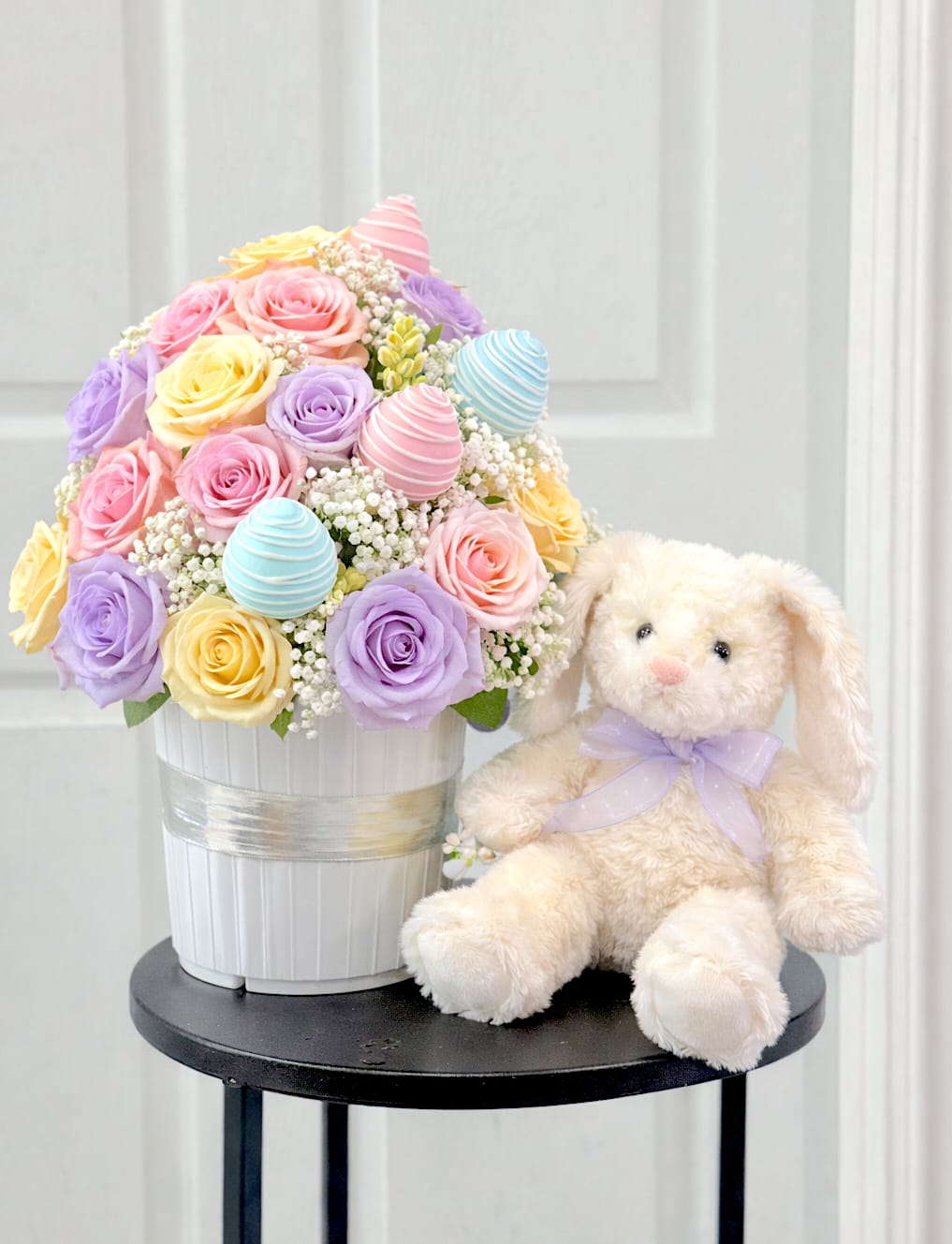 Bunny Bloom - A soft and elegant Easter arrangement featuring approximately 30–36 roses in delicate spring pastel tones, paired with six chocolate-covered strawberries and a charming plush bunny for the perfect seasonal touch.