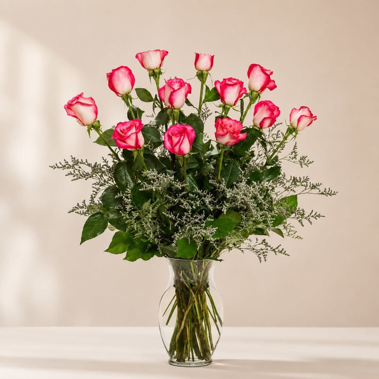 Pink and white roses arranged in a clear glass vase