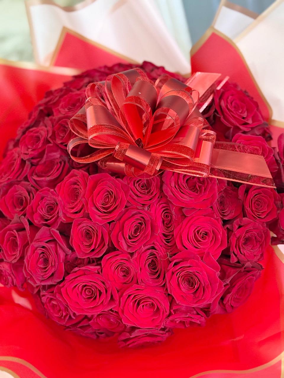 Large bouquet of red roses with a decorative ribbon bow