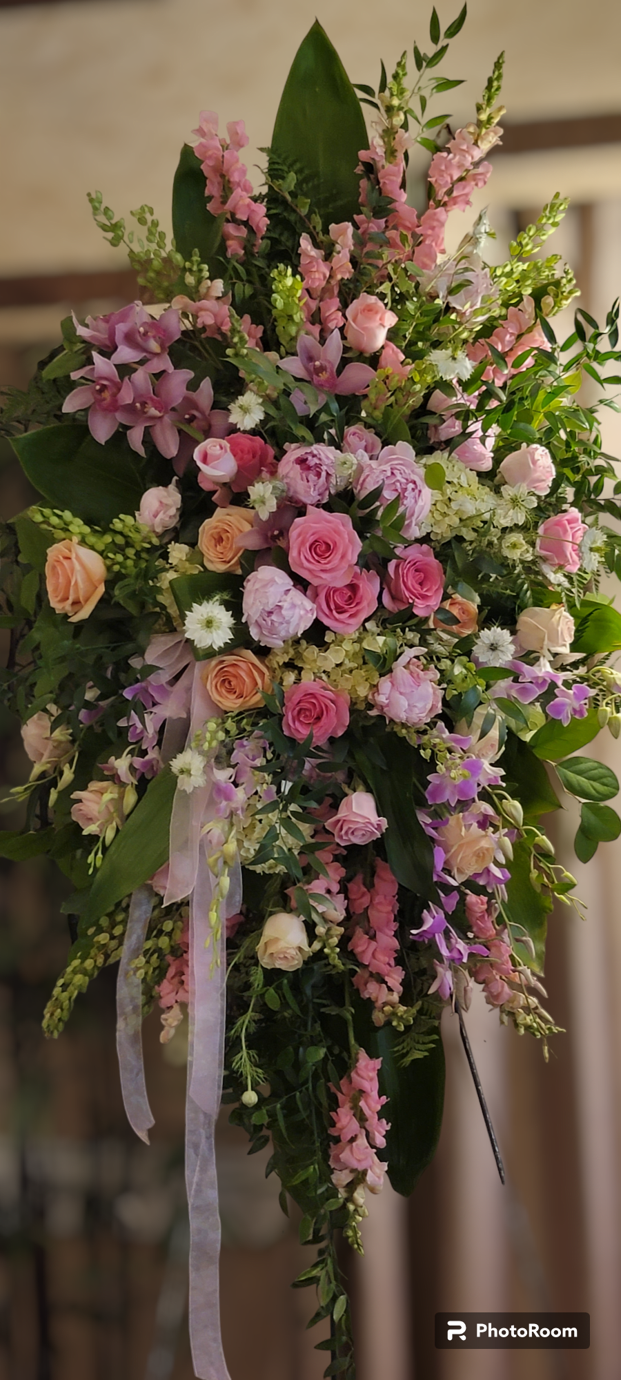 Pink Heaven - This glorious spray includes pink peony, light pink roses, light pink spray roses, pink oriental lilies, pink cymbidium, pink larkspur, pink snapdragons,  huckleberry, sword fern, asparagus plumosus, and greenery. Delivered on a wire easel.