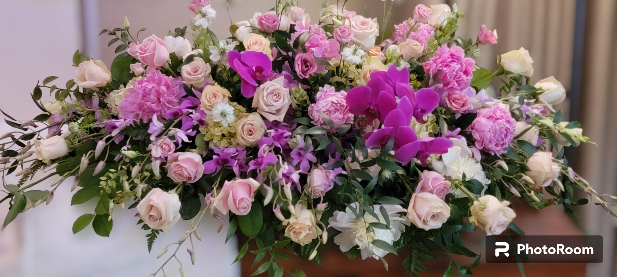 Large pink and white floral arrangement with roses and orchids