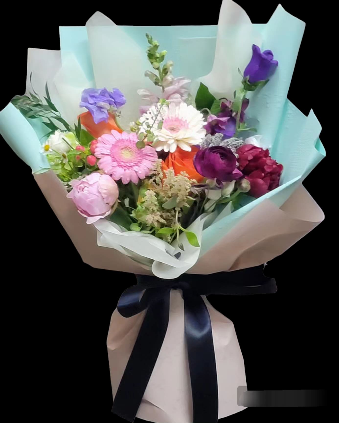 Mixed bouquet of pink, purple, white, and orange flowers wrapped in pastel paper