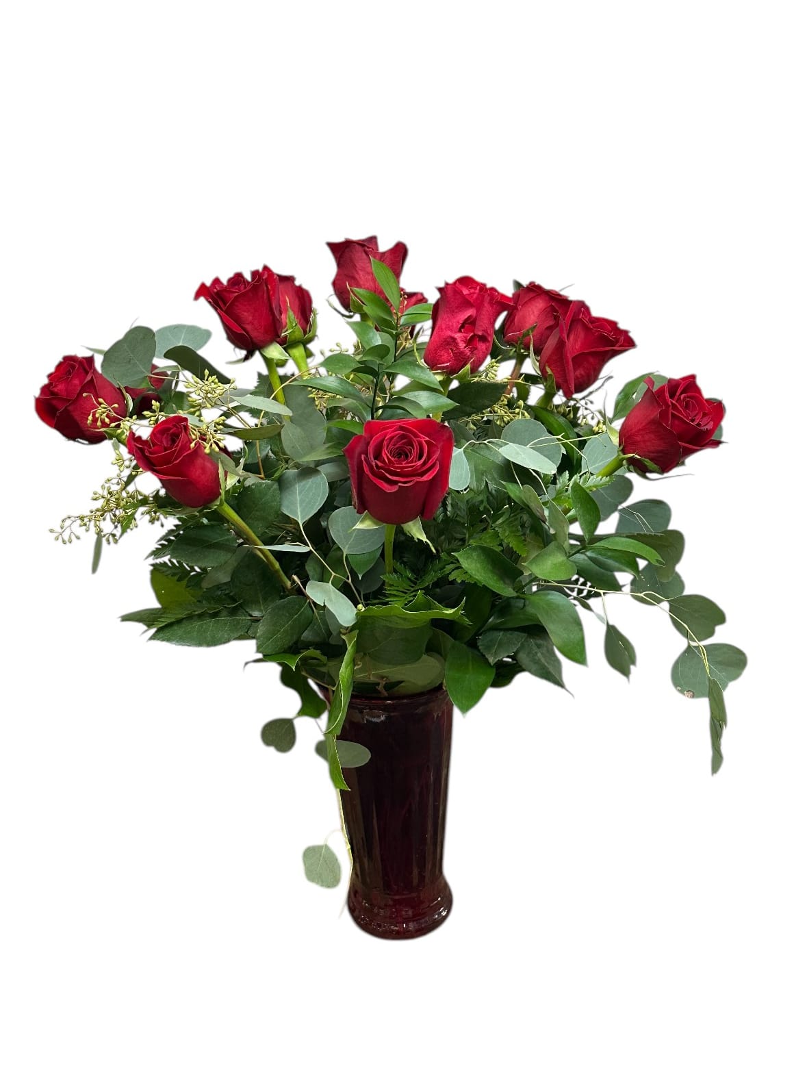 Red roses arranged in a tall dark vase with greenery