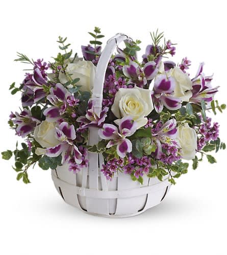 White roses and purple alstroemeria in a white basket