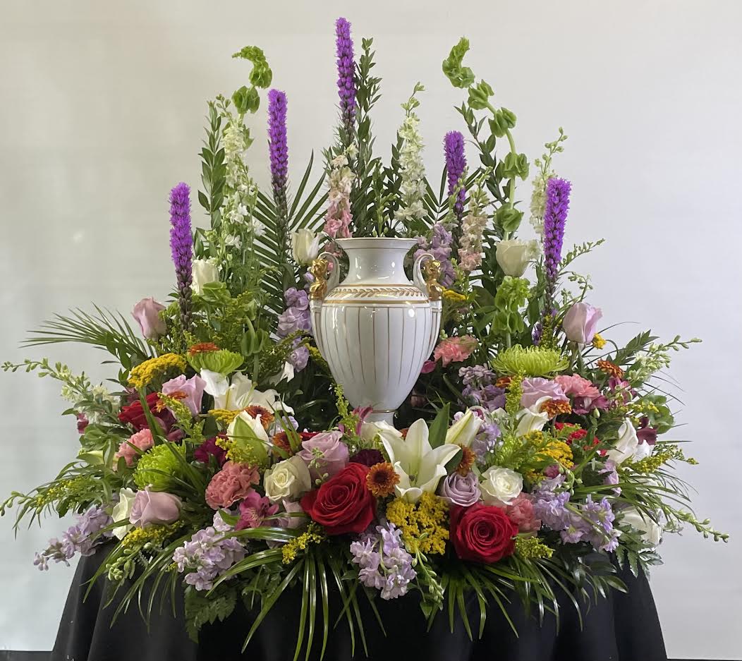 Large floral arrangement with a white urn centerpiece and mixed blooms