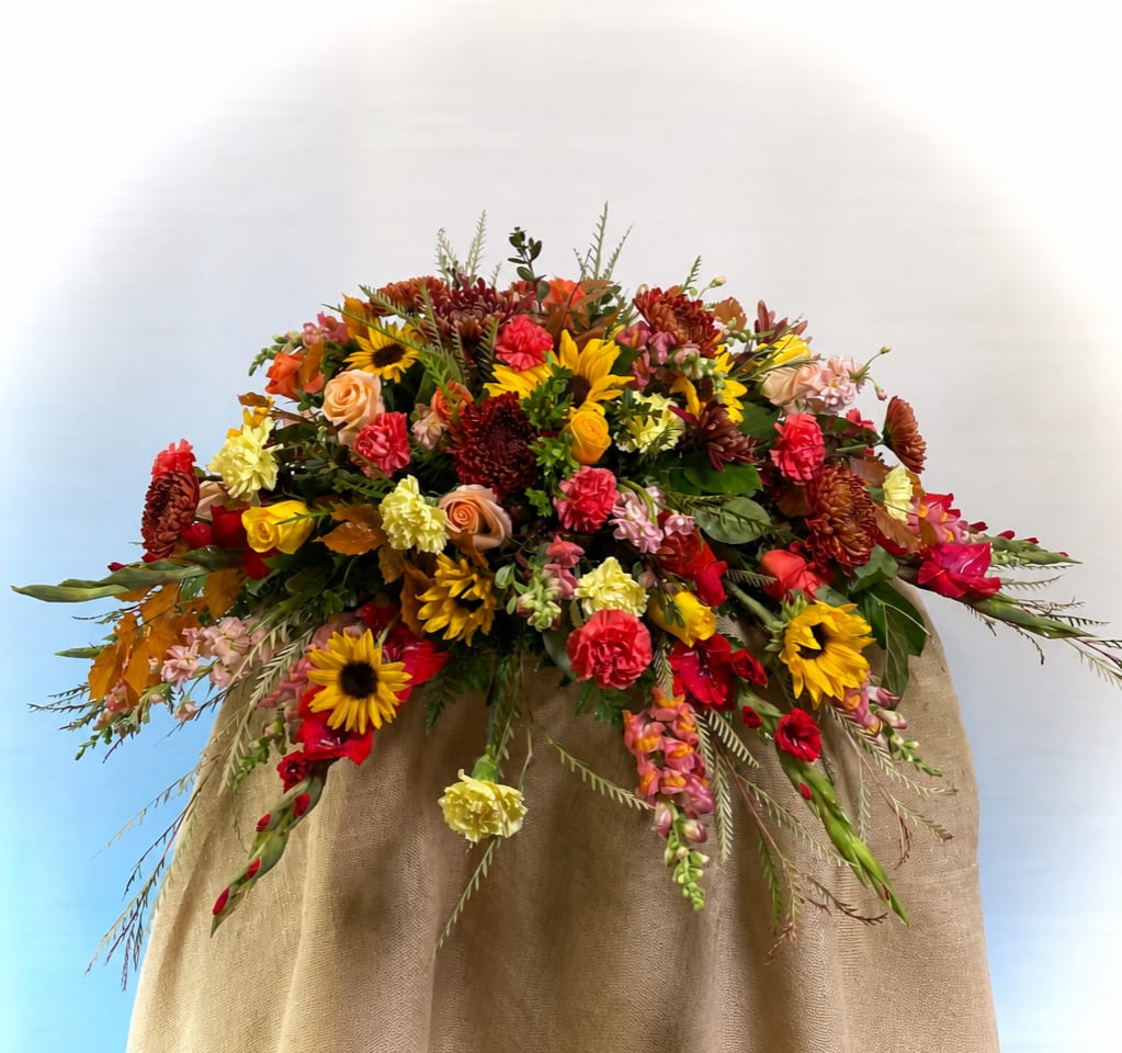 Large mixed bouquet with sunflowers, roses, and carnations in warm fall colors