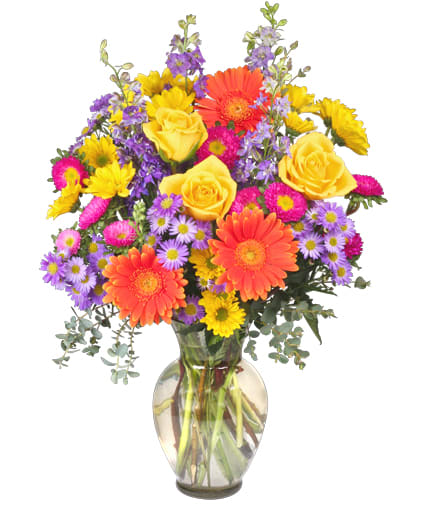 Colorful bouquet of yellow roses, orange gerberas, and purple daisies in a glass vase
