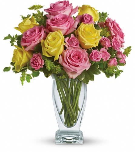 Pink and yellow roses arranged in a clear glass vase