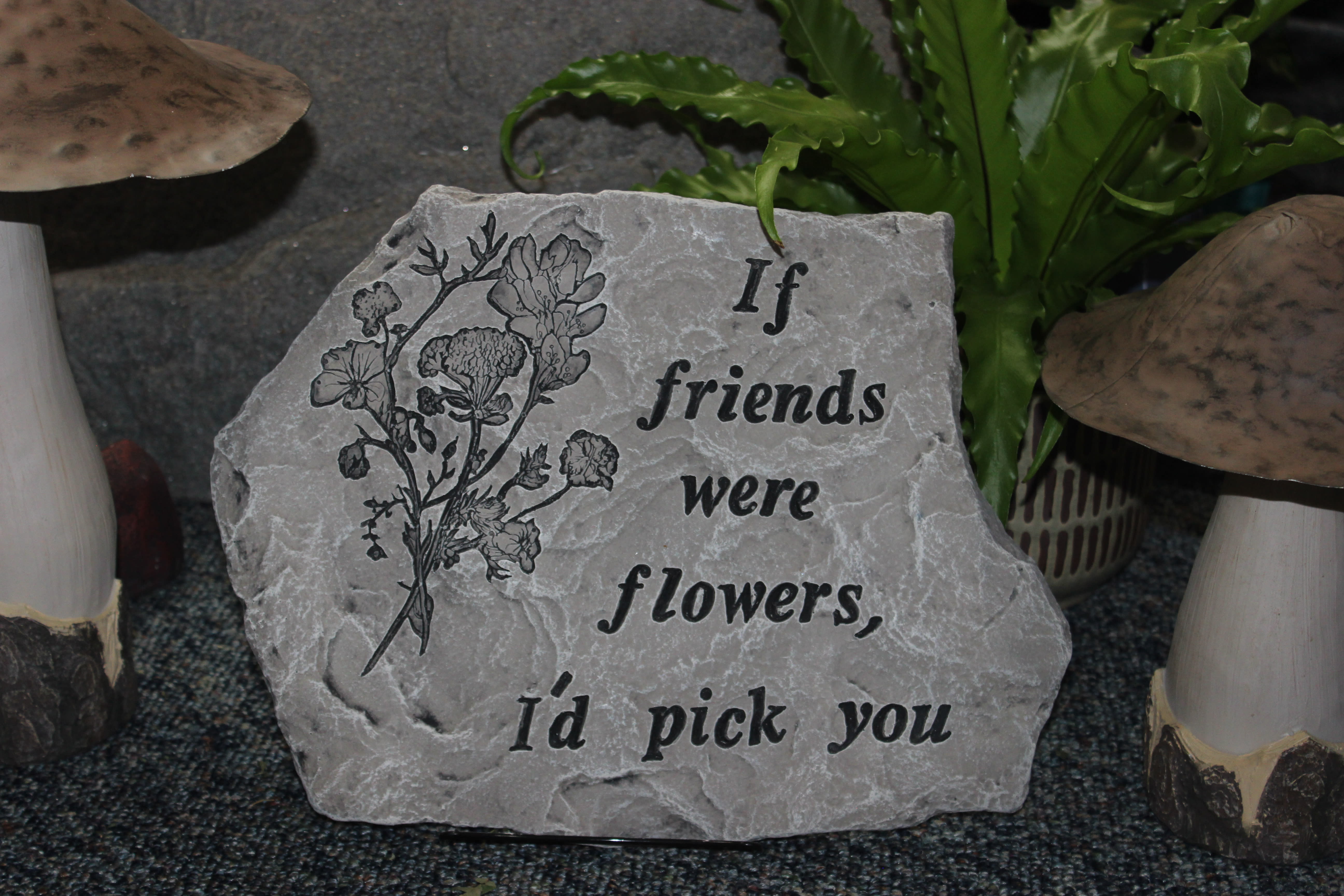 Engraved stone plaque with a flower illustration and friendship quote