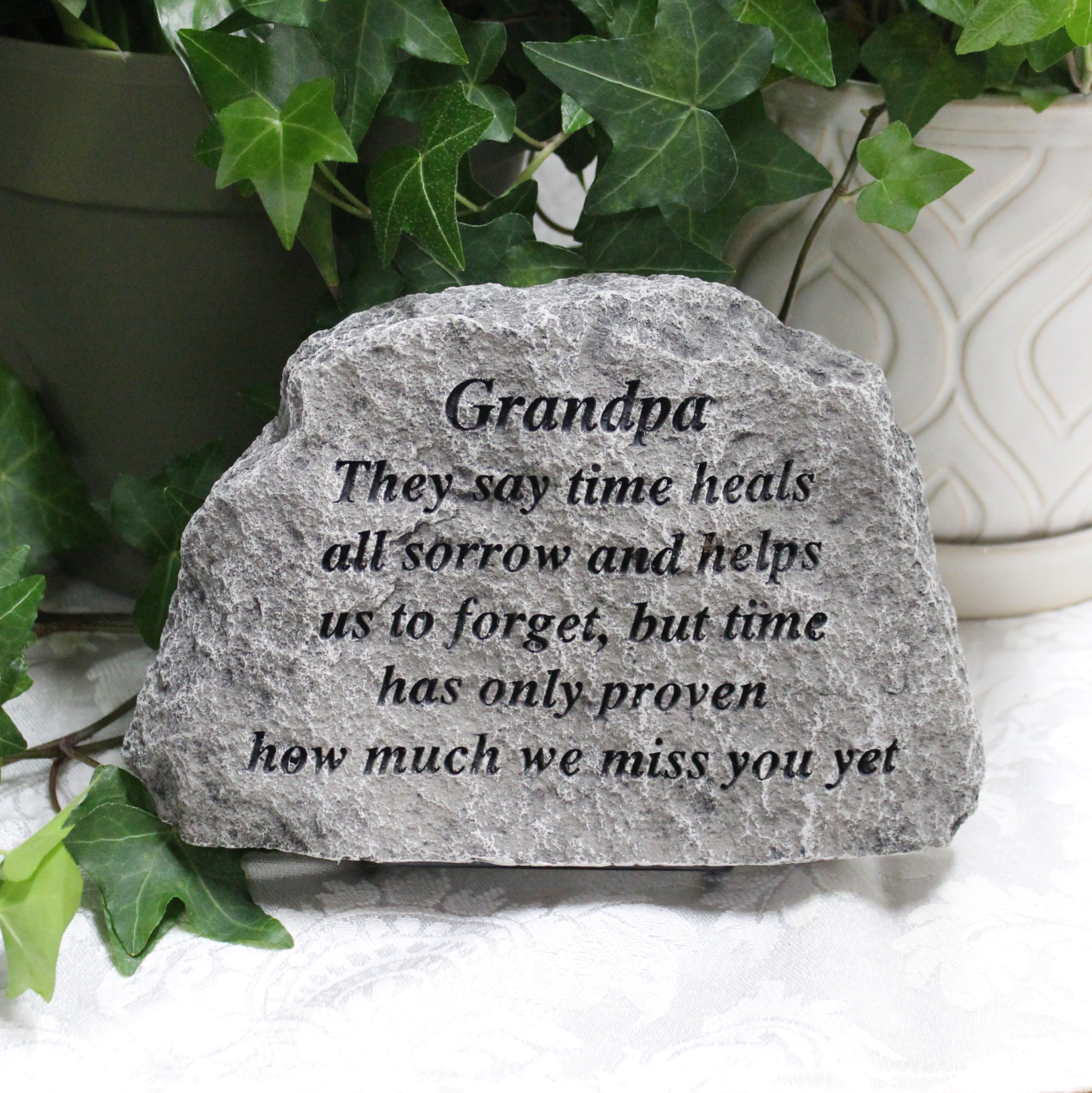Engraved memorial stone with ivy leaves in the background