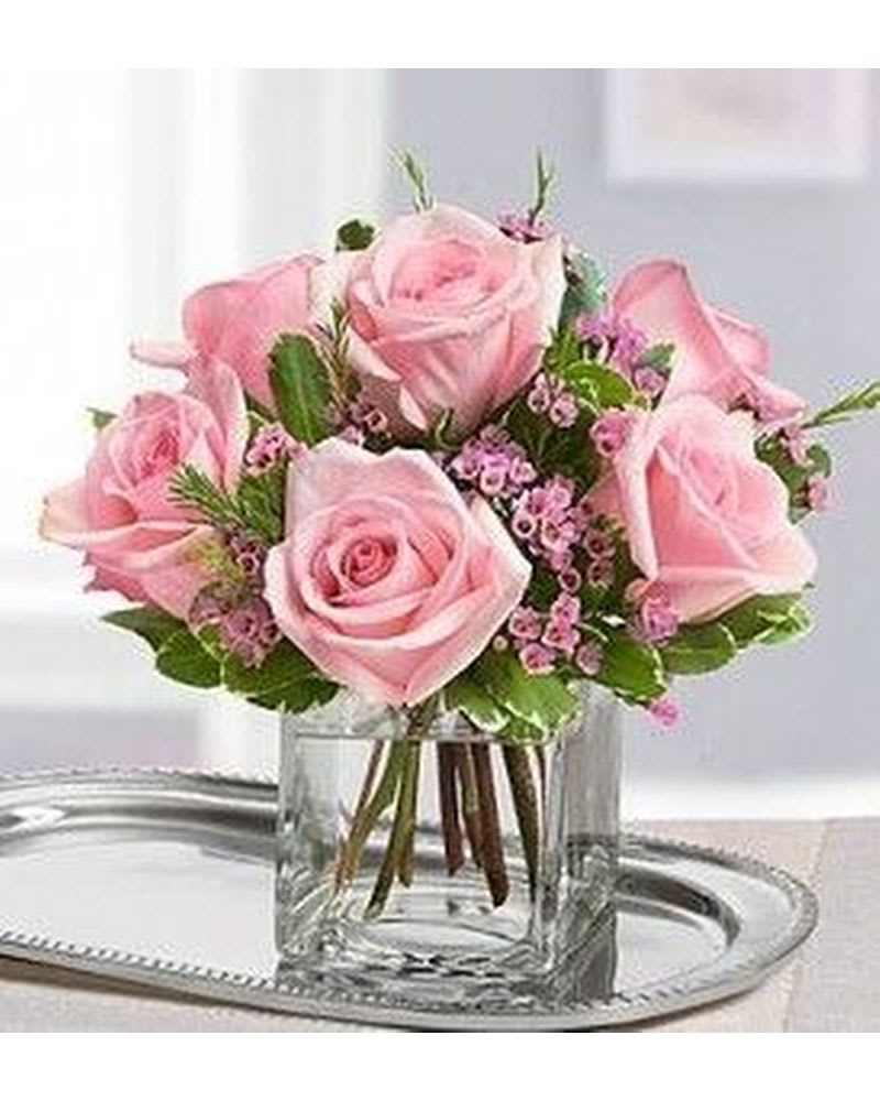 Pink roses arranged in a clear glass vase