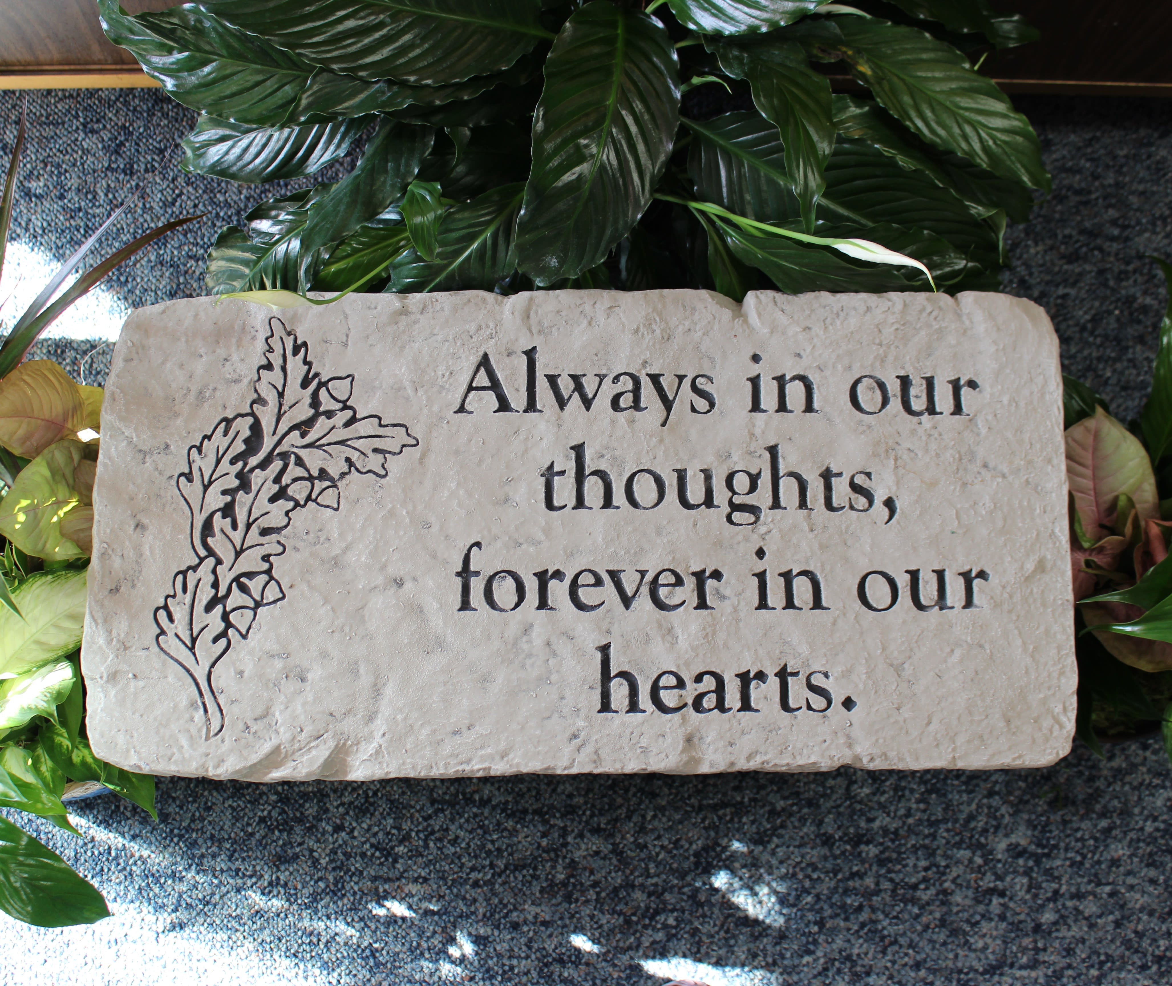 Memorial stone engraved with "Always in our thoughts, forever in our hearts."