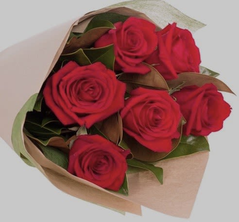 Bouquet of red roses wrapped in tan paper