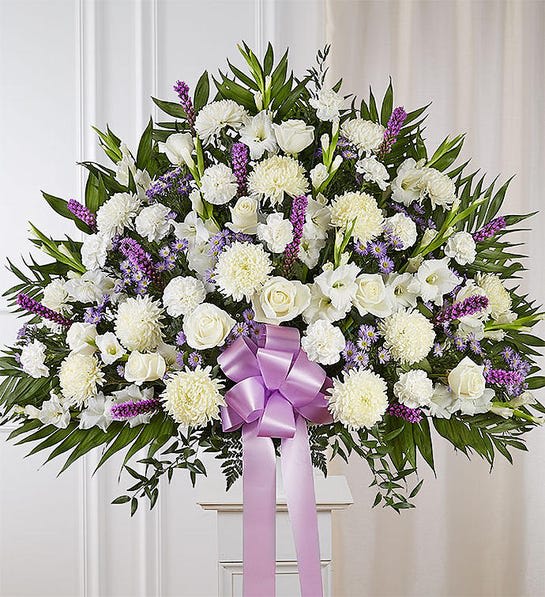 Large white floral standing spray with a lavender ribbon