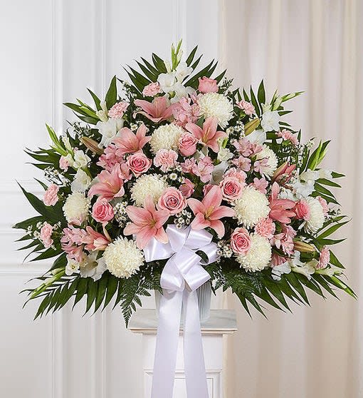 Large pink and white floral spray with a white ribbon bow