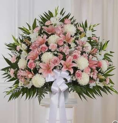 Large pink and white floral spray with a white ribbon bow