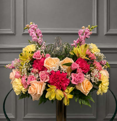 Large floral arrangement with pink, peach, and yellow flowers in a vase