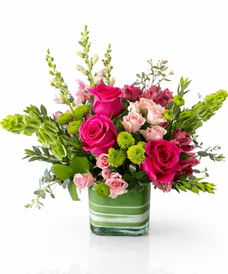 Garden Blush Delight - A vibrant mix of hot pink roses, soft blush blooms, and fresh green accents arranged in a modern glass cube—bringing a cheerful pop of color and natural elegance to any occasion.