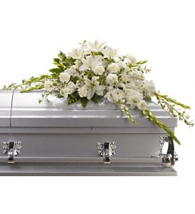 White floral casket spray on a silver casket
