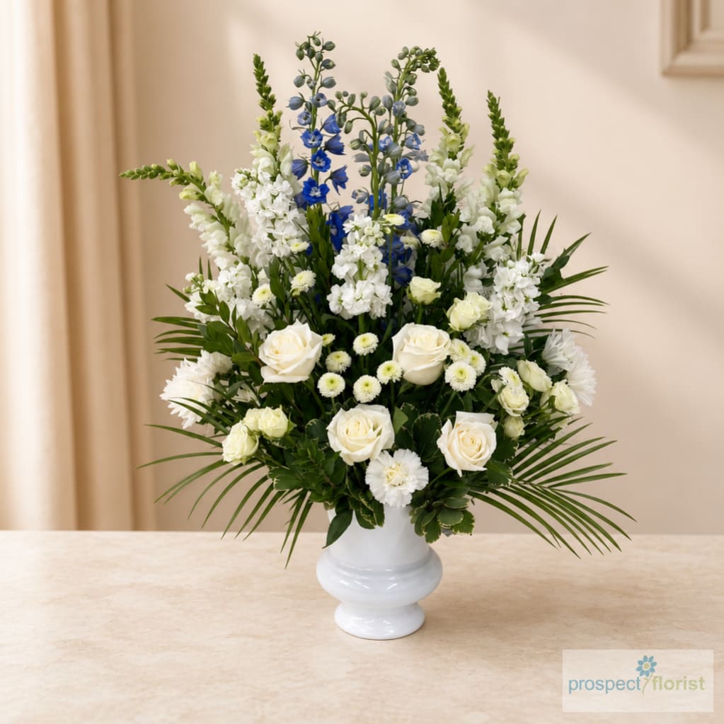 White and blue floral arrangement in a white vase