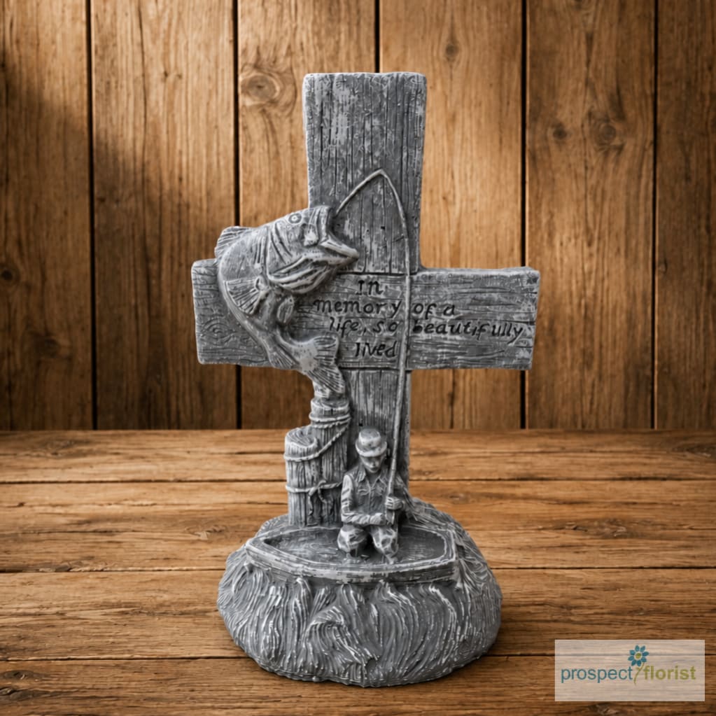 Gray memorial cross figurine with a fish and fisherman relief